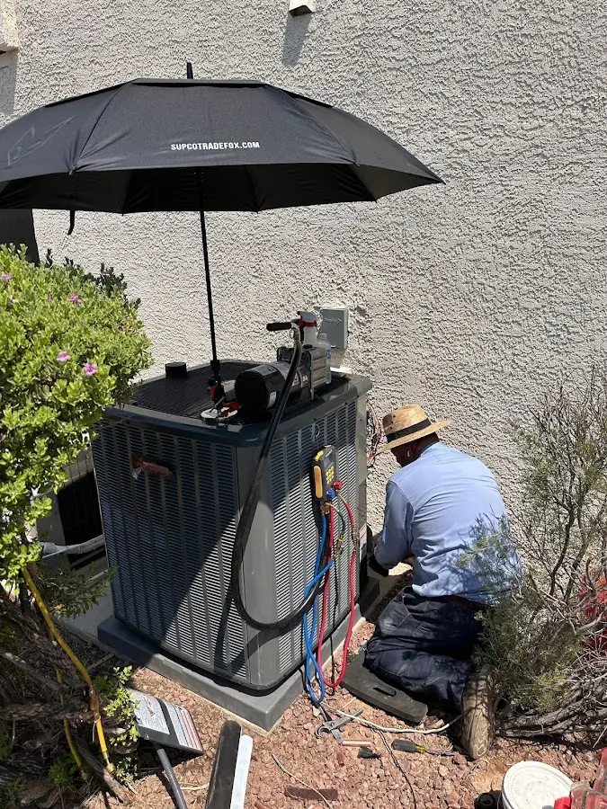 HVAC technician performing outdoor AC maintenance in Sturbridge