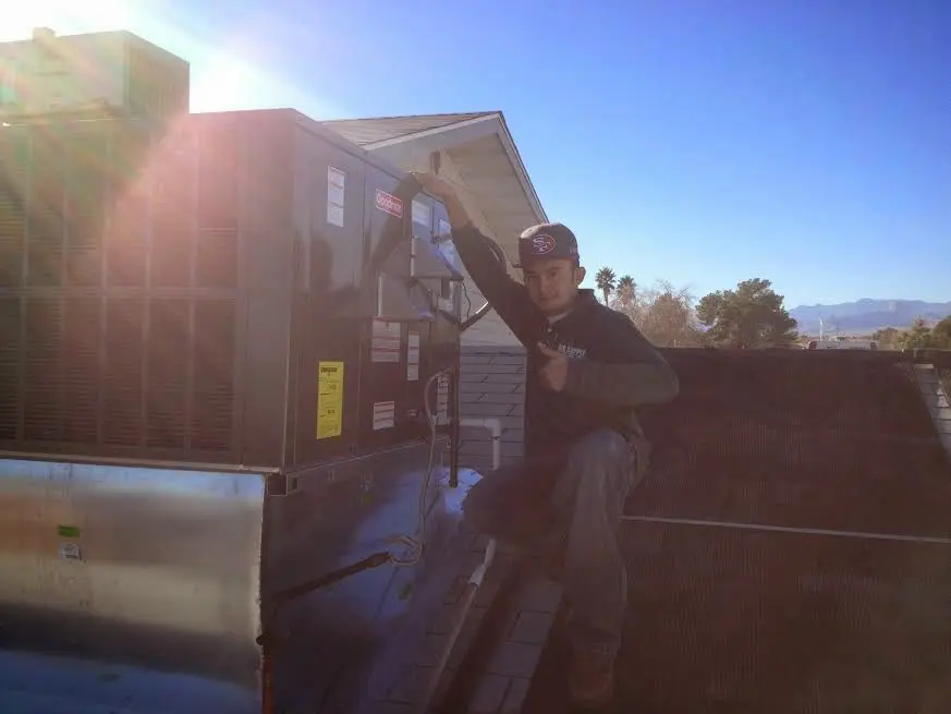 HVAC technician performing Heat Pump Repair on a rooftop unit in Sturbridge